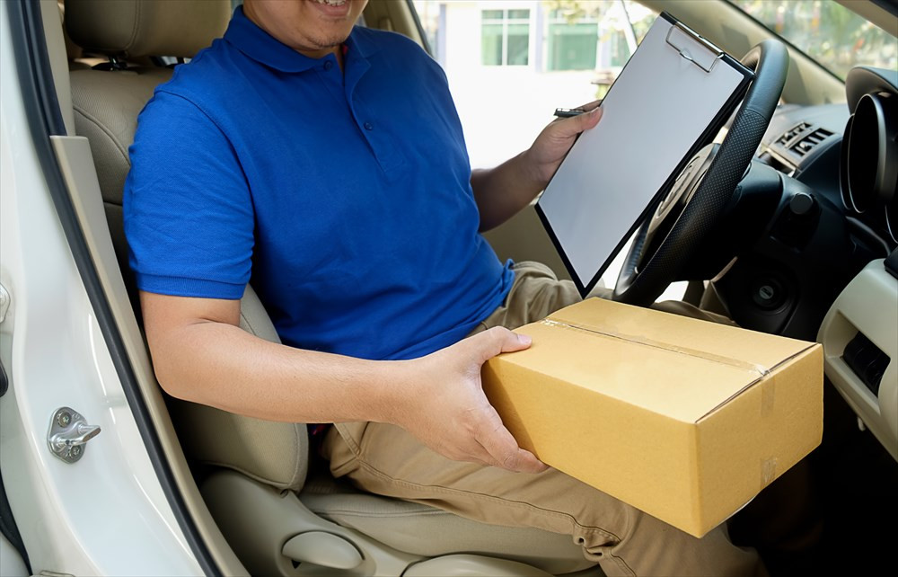 荷物を持って車から出てくる男性